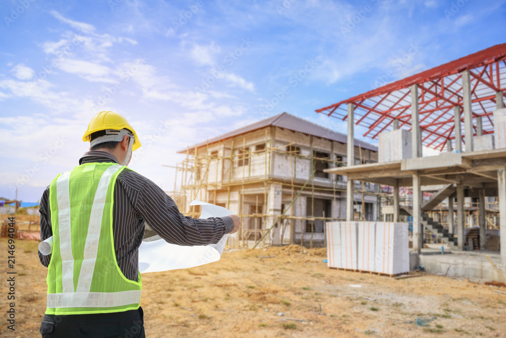 Professional engineer architect worker with protective helmet and blueprints paper at house building construction site Professional engineer architect worker with protective helmet and blueprints paper at house building construction site
