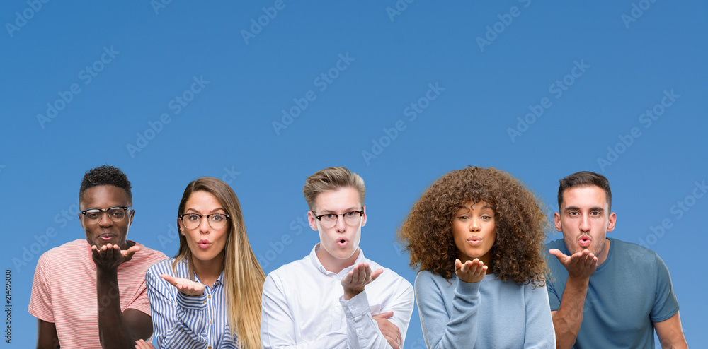 Composition of group of friends over blue blackground looking at the camera blowing a kiss with hand on air being lovely and sexy. Love expression. Composition of group of friends over blue blackground looking at the camera blowing a kiss with hand on air being lovely and sexy. Love expression.