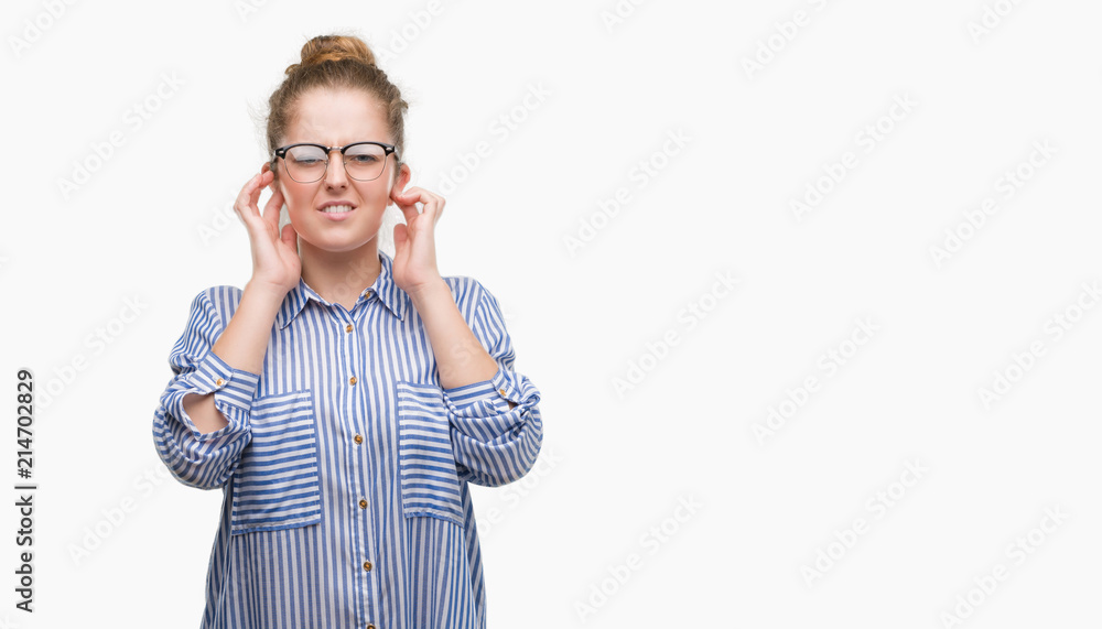 Young blonde business woman covering ears with fingers with annoyed expression for the noise of loud music. Deaf concept.