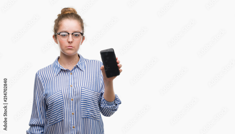 Young blonde woman using smartphone with a confident expression on smart face thinking serious Young blonde woman using smartphone with a confident expression on smart face thinking serious