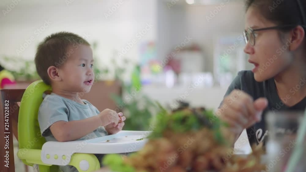 Asian boy about 2 year and 4 months eating fried fish feed by his mother Asian boy about 2 year and 4 months eating fried fish feed by his mother