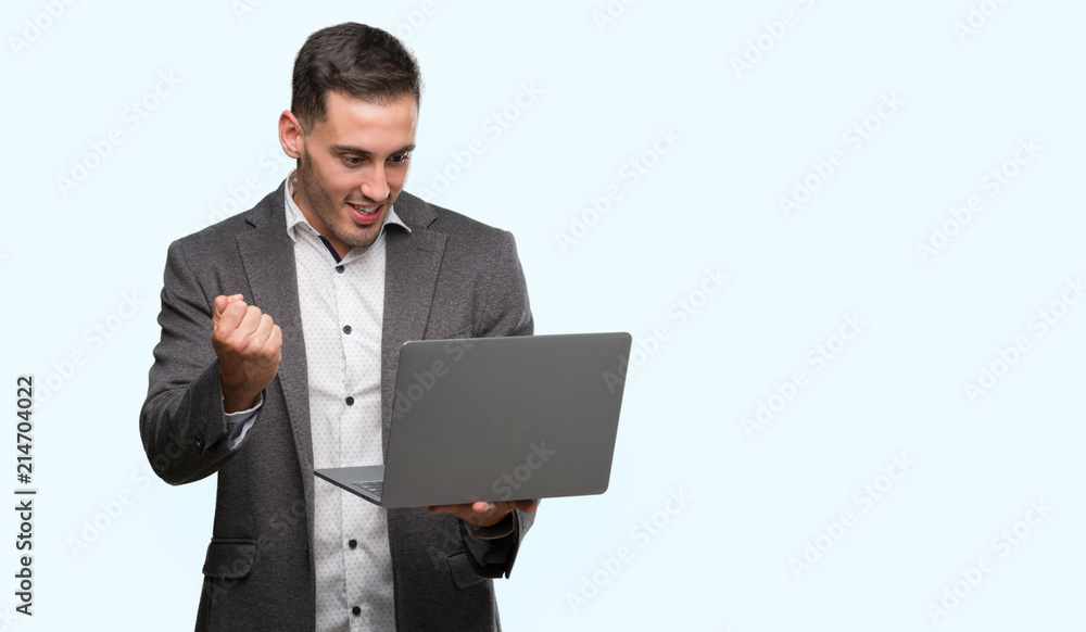 Handsome young man using computer laptop screaming proud and celebrating victory and success very excited, cheering emotion Handsome young man using computer laptop screaming proud and celebrating victory and success very excited, cheering emotion