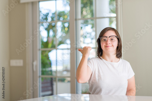 Down syndrome woman at home pointing and showing with thumb up to the side with happy face smiling Free Download Down syndrome woman at home pointing and showing with thumb up to the side with happy face smiling - GFXLoad