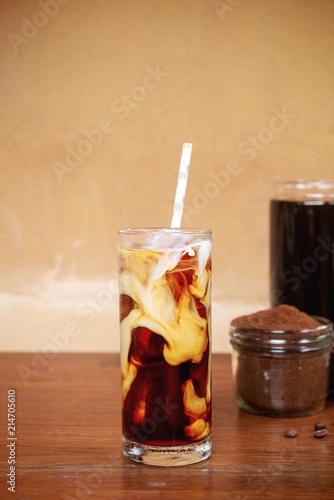 a glass of homemade cold cold brew coffee with milk on wooden table