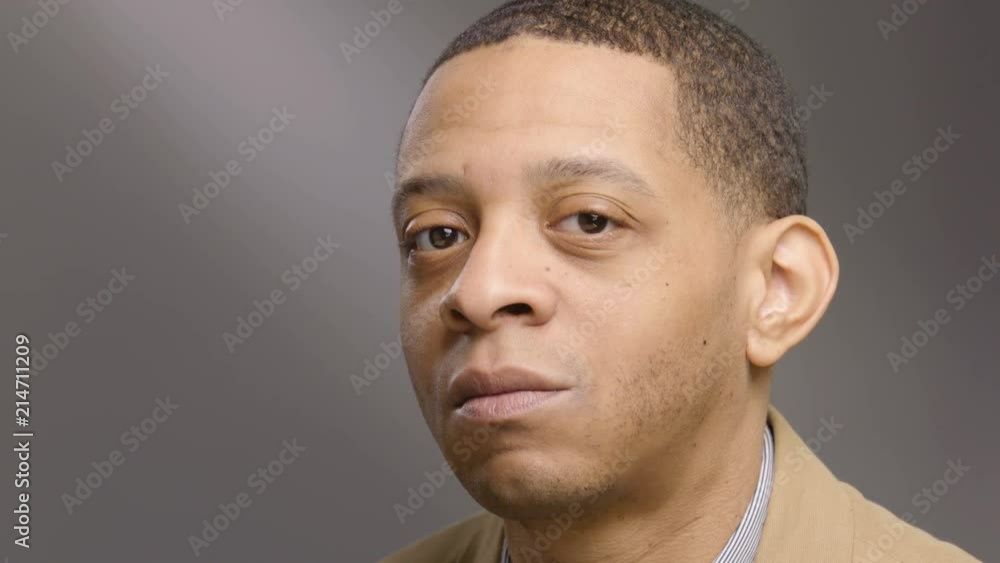 Portrait of a young black man looking at the camera, changing expressions Portrait of a young black man looking at the camera, changing expressions