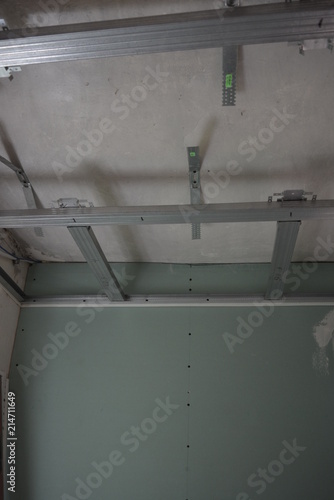 Construction and repair work of the ceiling of the room with guiding profiles on the walls, bridges and ceiling profiles with suspensions