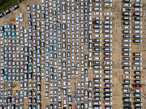 Top view of many new car lined up in row waiting send to dealer outside an automobile factory and waiting for export to other country.