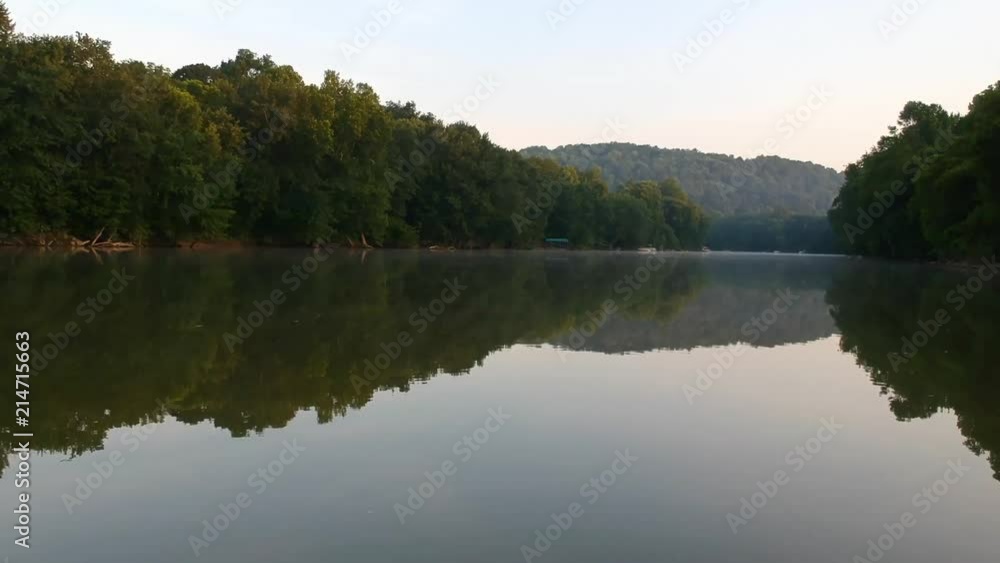 Riding down river with crystal smooth water and a fine mist of fog over the water in the distance. Riding down river with crystal smooth water and a fine mist of fog over the water in the distance.