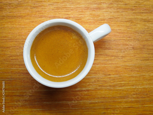 Cup of Espresso coffee on wood board background, Arabica with crema
