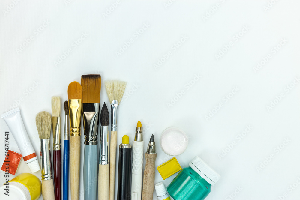 Obraz premium various brushes and paints on white background. painting tools flat lay
