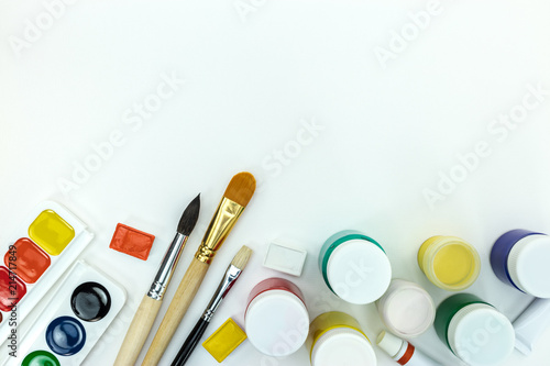 bright colored paints and set of brushes on white background. school painter tools flat view