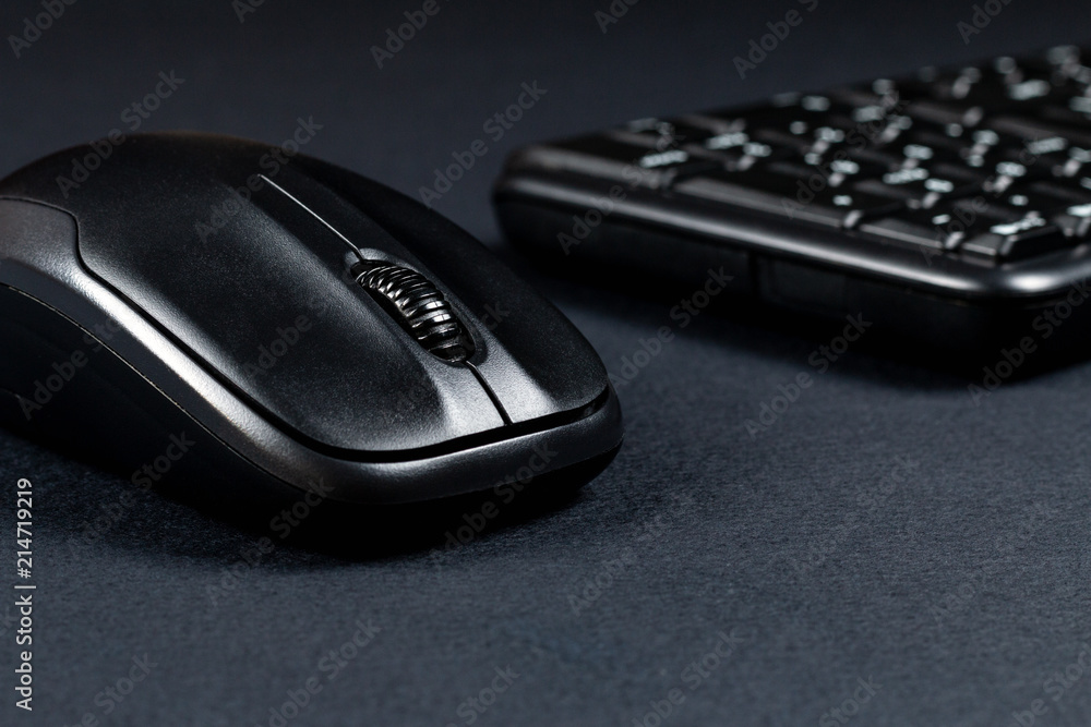 Wireless mouse with black keyboard on black surface Wireless mouse with black keyboard on black surface
