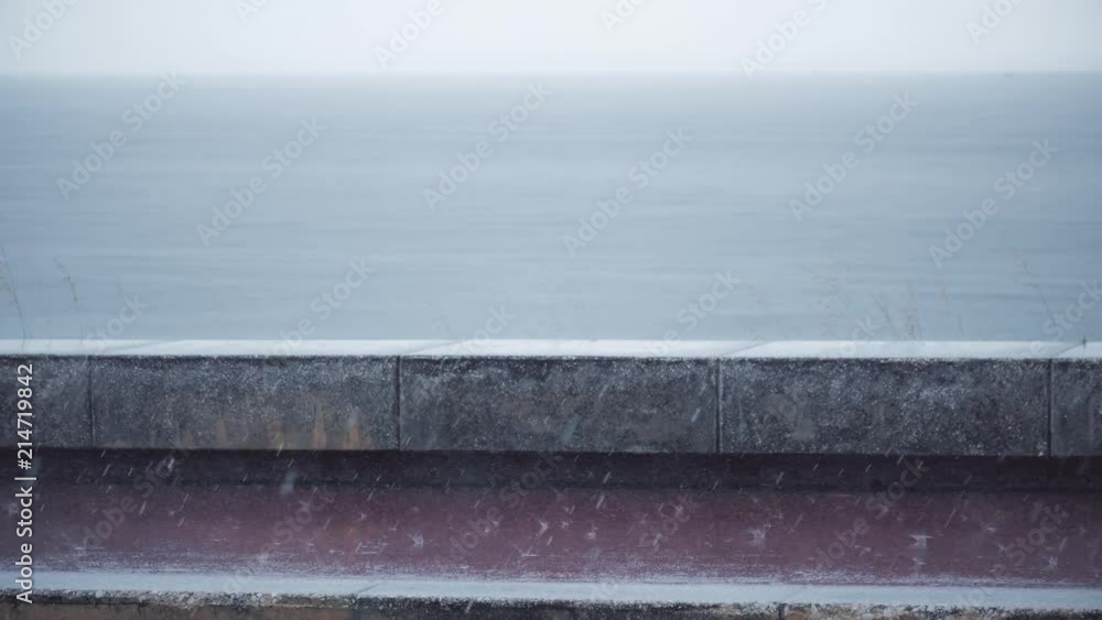 Heavy rain drops on asphalt, rain on the waterfront.