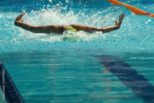 Swimmer wearing yellow cap practice butterfly stroke in a swimming pool for competition or race © wibulpas