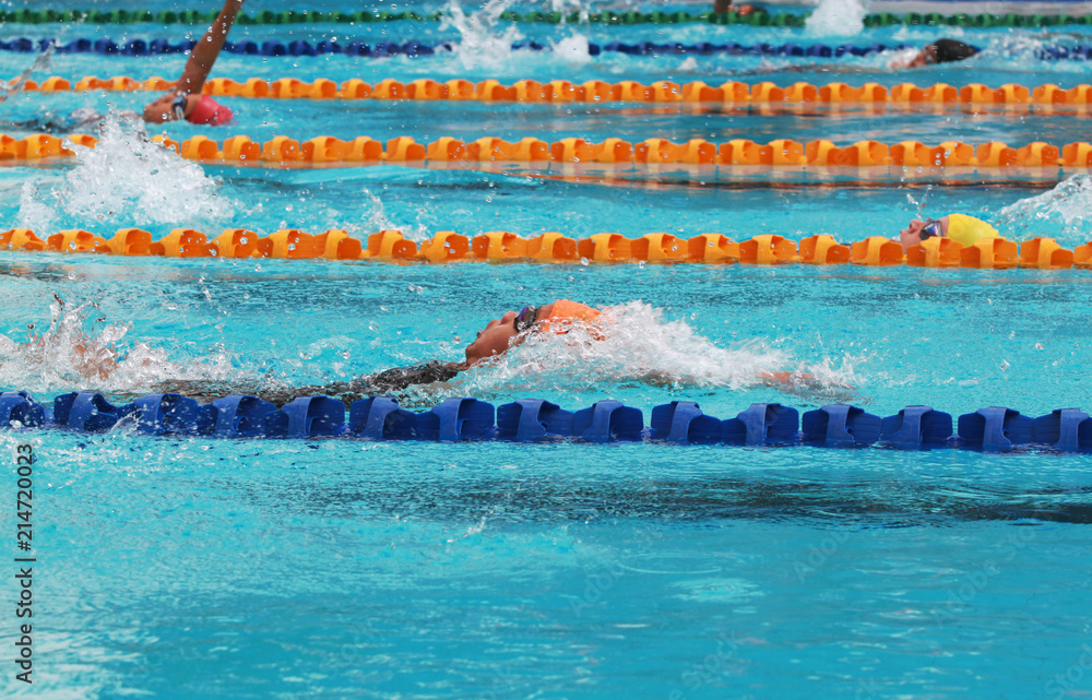 Swimmers swim backstroke or back crawl in a swimming pool for competition or race