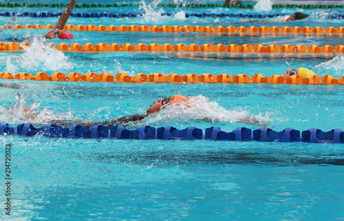 Swimmers swim backstroke or back crawl in a swimming pool for competition or race