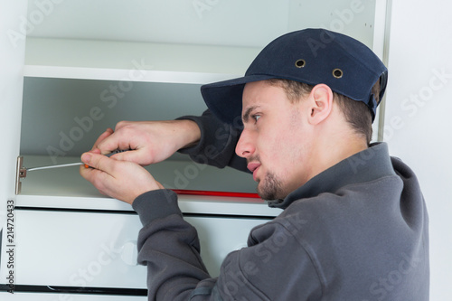 handyman fixing the cupboard in the kitchen