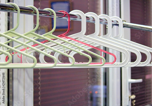 Empty hangers on the rack for clothes. Office space or school. Selective focus, side view, copy space. photo