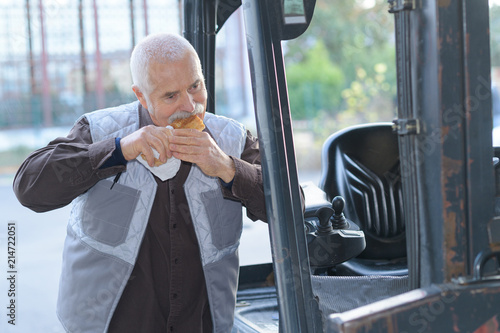 Fork lift driver eating a sandwich photo