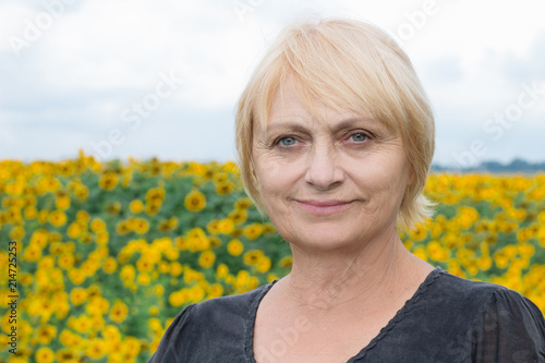 Headshot portrait, smiling aged white woman, direct look, light eyes