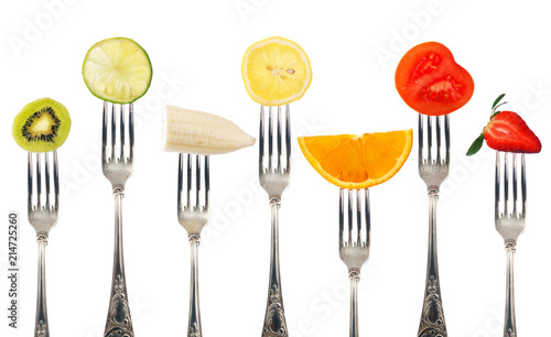 Variety of fruit pieces on silver forks isolated on white background