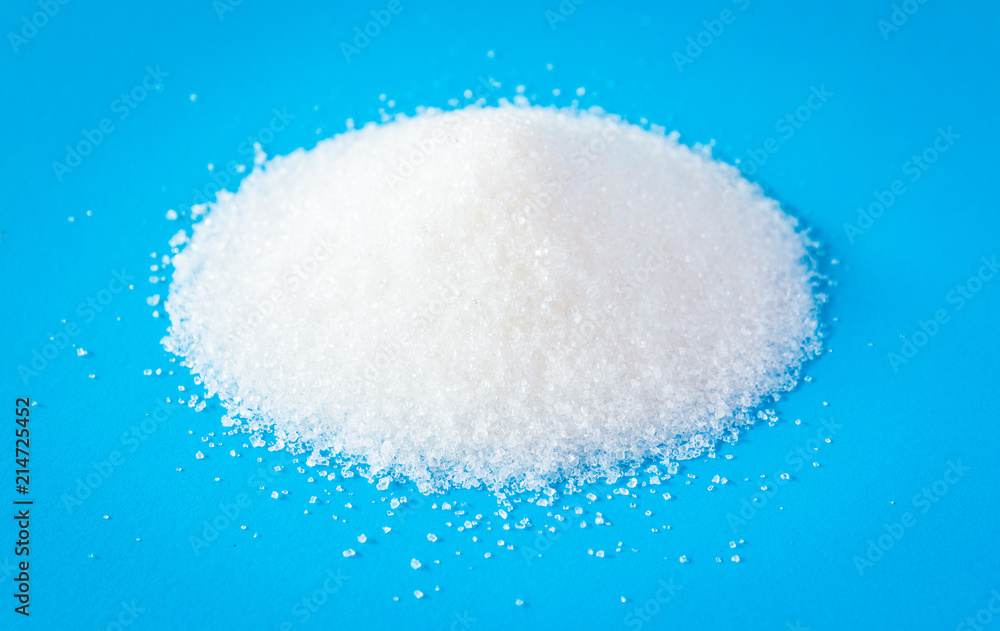Heap of sugar on blue background