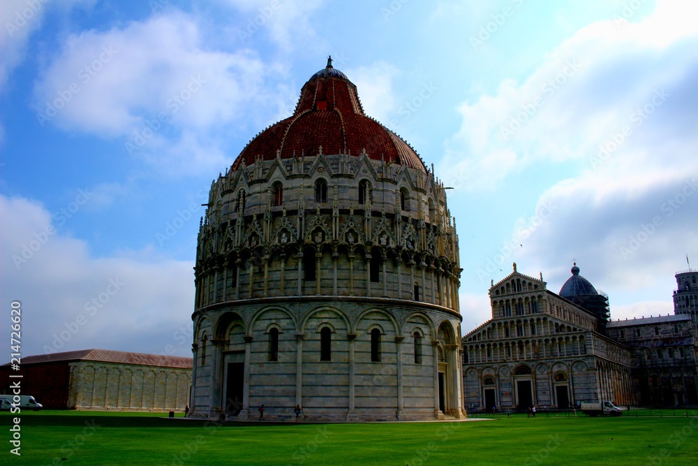 A wide angle view of the Baptistery in Pisa, Italy and the buildings behind it