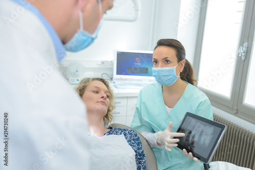 woman patient at dental surgery point teeth xray tablet dentist