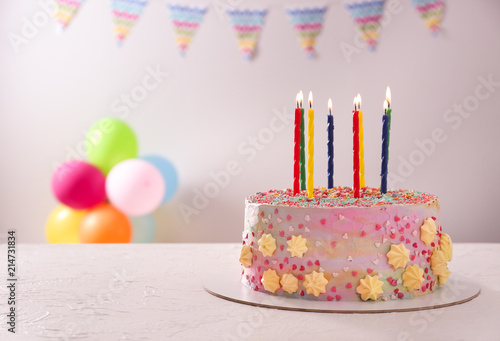 Beautiful tasty birthday cake with candles on white table