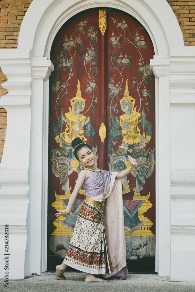 Obraz premium Cute Thai girl wearing thai traditional clothing. She posing traditional dancing.