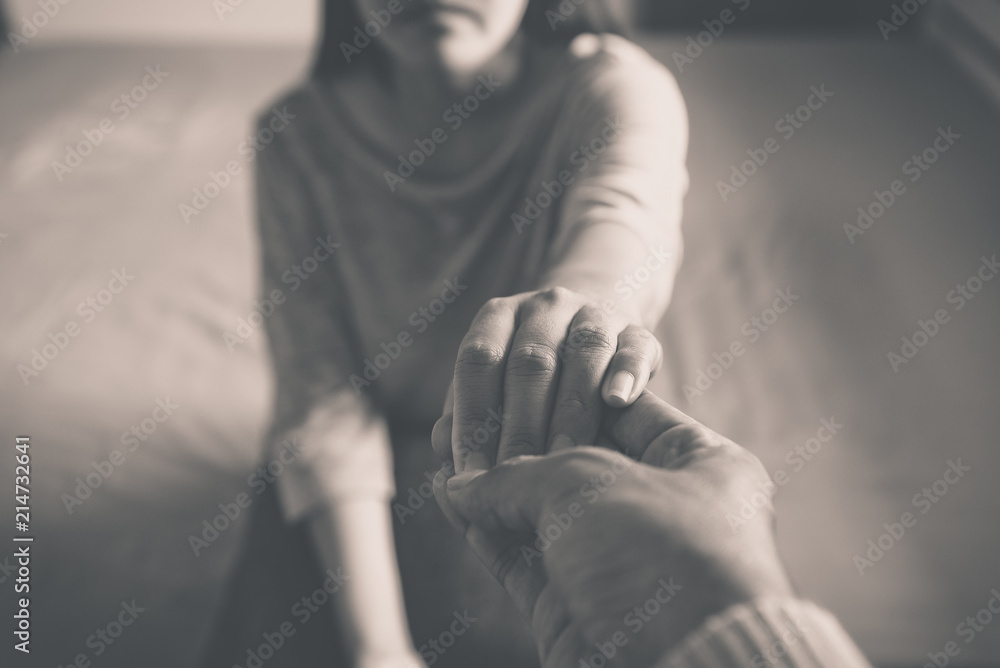 Man giving hand to depressed woman patient,Personal development including life coaching therapy sessions and speech therapy,Mental health care concept,Black and white toned