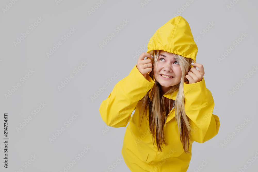 Woman in a yellow raincoat on a gray background Woman in a yellow raincoat on a gray background