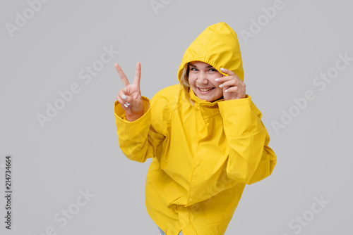 Woman in a yellow raincoat on a gray background