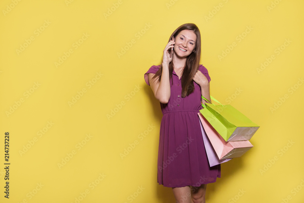 beautiful casual girl with shopping bag talking on mobilephone