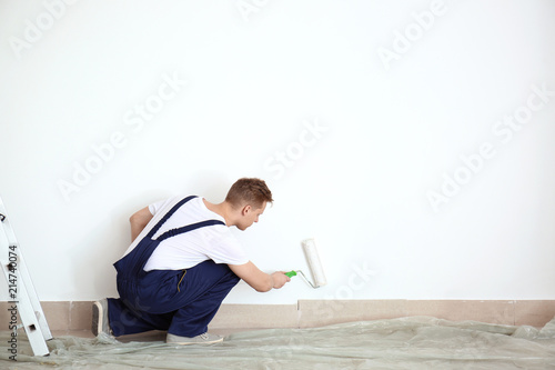 Male painter using roller f...