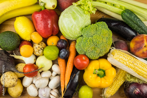 Close-up top view image of fresh organic vegetables and fruit. Locally grown bell pepper, corn, carrot, mushrooms and other natural vegan food laying on table.