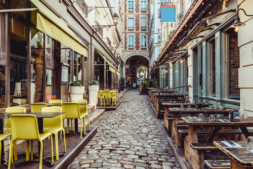 Cozy street near Boulevard San-German with tables of cafe and pub  in Paris, France photo