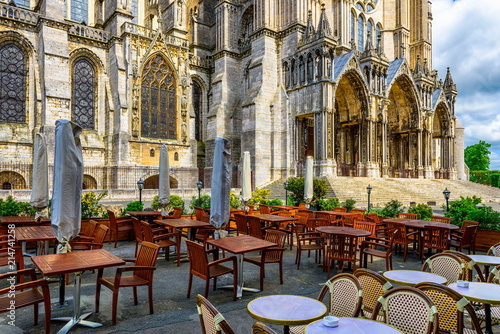 Old street with Chartres Cathedral and tables of cafe in a small town Chartres, France