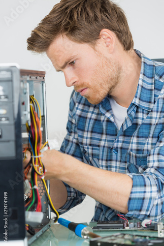 handsome computer engineer repairing a faulty pc photo