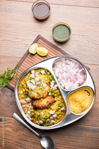 Ragda Pattice is a popular Street food or chat made of potato Patties. served in a steel plate, bowl or ceramic plate with tamarind and cilantro chutney