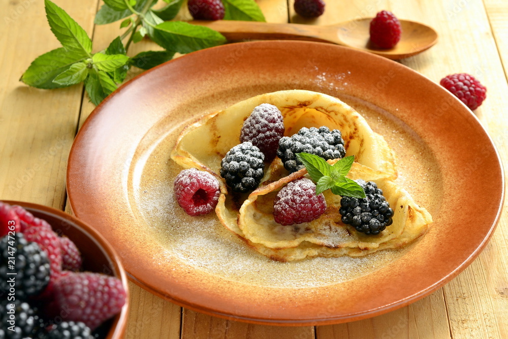 Pancakes, fresh berries sprinkled with powdered sugar - delicious breakfast Pancakes, fresh berries sprinkled with powdered sugar - delicious breakfast