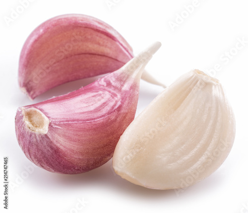 Peeled and unpeeled garlic cloves on white background.