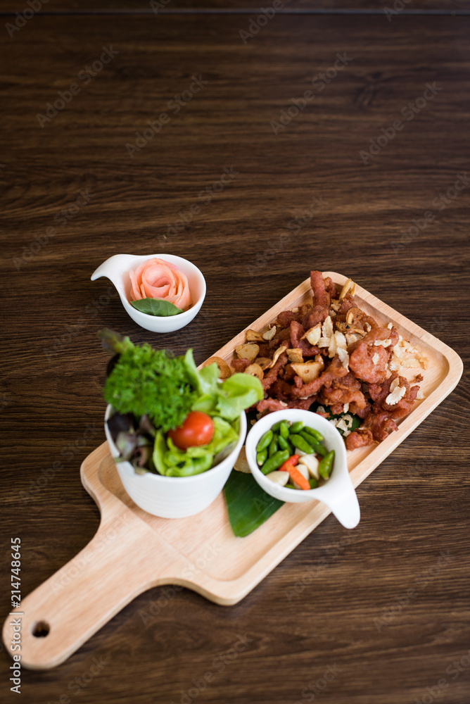 Fried Pork with Garlic. Deep Fried Crispy Pork Belly Cooked with Garlic and spicy dipping sauce on wooden table background Fried Pork with Garlic. Deep Fried Crispy Pork Belly Cooked with Garlic and spicy dipping sauce on wooden table background