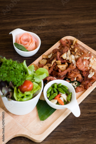 Fried Pork with Garlic. Deep Fried Crispy Pork Belly Cooked with Garlic and spicy dipping sauce on wooden table background