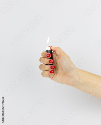 black lighter with fire in woman's hand isolated on white background