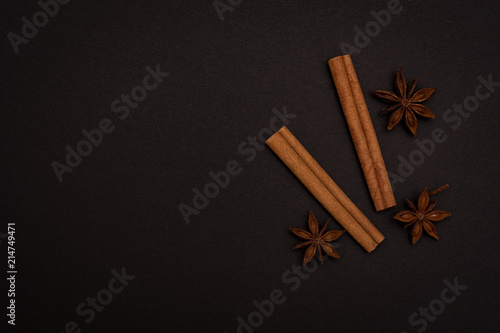 cinnamon sticks and cardamom on a black background top view with copy space for text