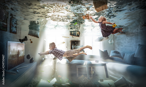  creative and abstract image, flooded living room, floating objects and children playing as if nothing had happened. concept of carelessness to domestic problems and disasters. lightheartedness