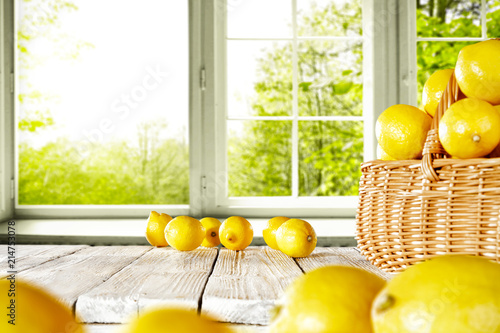 Fresh yellow lemon on white wooden table and free space for your bottle or glass. Window background of summer time. 