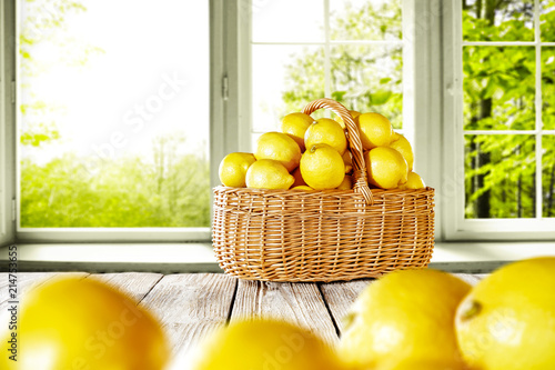 Fresh yellow lemon on white wooden table and free space for your bottle or glass. Window background of summer time. 