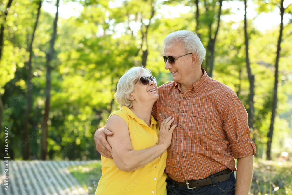 Happy mature couple walking in city park Happy mature couple walking in city park